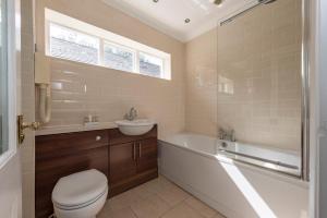 a bathroom with a toilet and a sink and a tub at Statham Lodge Hotel in Warrington