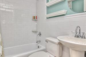 a white bathroom with a toilet and a sink at Bungalow Beach Place 6 in Clearwater Beach