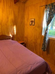 a bedroom with a bed and a window at Parcela borde rio in Villarrica