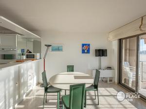 eine Küche und ein Esszimmer mit Tisch und Stühlen in der Unterkunft Appartement T2 face plage avec garage aux Sables-d'Olonne - FR-1-197-213 in Les Sables-dʼOlonne + 5 Fotos