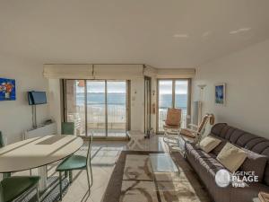 ein Wohnzimmer mit Sofa und Tisch in der Unterkunft Appartement T2 face plage avec garage aux Sables-d'Olonne - FR-1-197-213 in Les Sables-dʼOlonne
