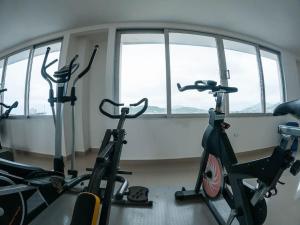 un gimnasio con 2 bicicletas estáticas en una habitación con ventanas en Hermoso apto cerca a la playa Bello Horizonte, en Santa Marta