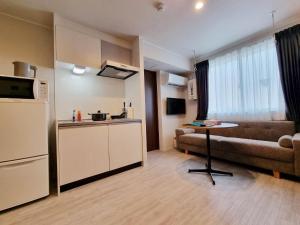 eine Küche mit einer Couch und einem Tisch in einem Zimmer in der Unterkunft PRISM INN Asakusa in Tokio