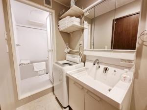 baño con lavabo y espejo grande en PRISM INN Asakusa en Tokio
