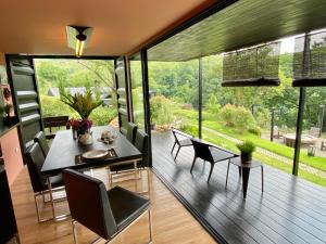 a dining room with a table and chairs and large windows at 98 Mae Ram Residence in Ban Thung Pa Haeo