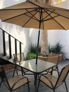 una mesa y sillas con una sombrilla en el patio en MEJOR OPCION EN CENTRO HISTÓRICO DE LA CIUDAD DEP6 en Chihuahua
