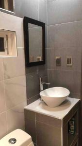 La salle de bains est pourvue d'un lavabo, de toilettes et d'un miroir. dans l'établissement MEJOR OPCION EN CENTRO HISTÓRICO DE LA CIUDAD DEP6, à Chihuahua