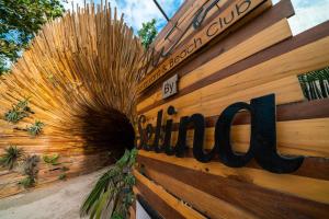 un panneau sur une clôture en bois avec un panneau sur celle-ci dans l'établissement Selina Tulum, à Tulum