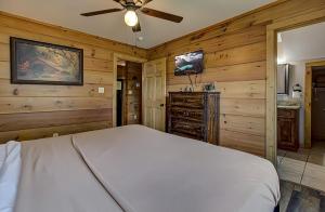 1 dormitorio con 1 cama y ventilador de techo en Bear Cove Falls #4133 en Pigeon Forge