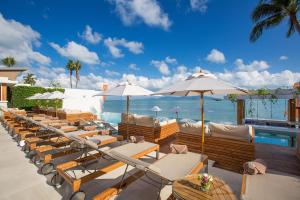 a row of chairs and umbrellas next to the ocean at Chi - The Residence in Bophut 