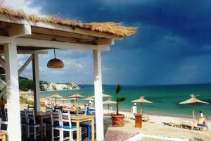 - une plage avec des tables, des parasols et l'océan dans l'établissement Black Sea Rama Golf and Villas, Bell Tower, à Balchik