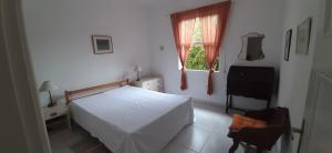 a bedroom with a white bed and a window at Casa Itaipava Country Club in Petrópolis +26 photos