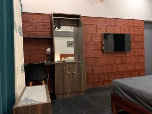a room with a mirror and a tv on a wall at Aambal Villa Homestay in Meenangadi