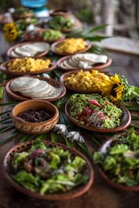 a table with plates of food and bowls of vegetables at Selina Tulum in Tulum