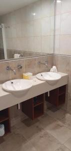 Baño con 2 lavabos y espejo en Lakefront Apartments,18 LAKE ESPLANADE ROAD en Queenstown