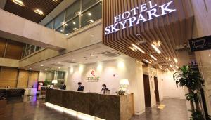 a lobby of a hotel with two people at a counter at Hotel Skypark Dongdaemun I in Seoul