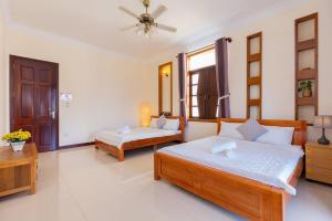 a bedroom with two beds and a ceiling fan at Hoàng My Villa 28-10 in Vung Tau +36 photos