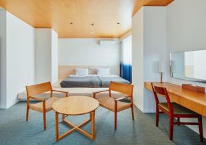 Habitación de hotel con cama, mesa y sillas en Hotel Graphy Nezu, en Tokio
