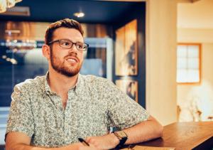 a man with glasses sitting at a table at Hotel Graphy Nezu in Tokyo