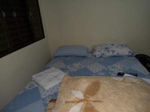 a small bedroom with two beds and a window at Pousada Catarina in Maringá