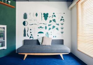 a couch in a room with a wall with plants at Hotel Graphy Nezu in Tokyo