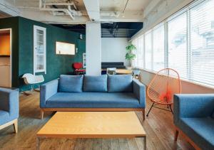 a living room with a blue couch and chairs at Hotel Graphy Nezu in Tokyo