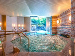 a large swimming pool in a room with a large window at Yuzawa Toei Hotel in Yuzawa