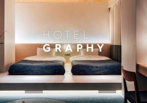 two beds in a room with the words hotelaria at Hotel Graphy Nezu in Tokyo