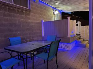 a table and chairs on a deck with purple lights at Comfortable Bungalow near Liberty Park in Salt Lake City