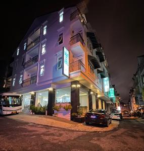 un edificio púrpura con un coche aparcado delante de él en Dalat Eco Hotel, en Da Lat