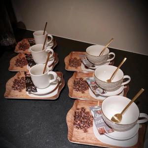 un grupo de tazas de café y platillos sobre una mesa en B&B Hope & Anchor en Averbodeheide