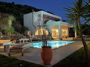 a villa with a swimming pool in front of a house at SHIGAYA Boutique Villa in Plaka +63 photos