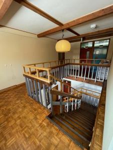 Habitación con escalera de madera y lámpara de araña. en さくら山荘, en Omachi