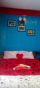 ein blaues Schlafzimmer mit einem Bett mit einer roten Decke in der Unterkunft Kabiraalaya Homestay in Darjeeling