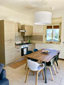 a kitchen with a wooden table and chairs at playa home in Catania