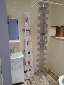 un bagno con lavandino e tenda da doccia di R i A N A 3 a Eforie Sud Altre 10 foto