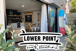 a sign for a lower point surf shop with a surfboard at Lower Point Surf Studio 2 in Jeffreys Bay