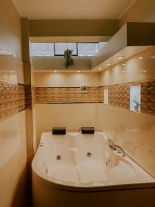 a bathroom with a bath tub and a sink at Santa Lucía Suite Hotel in Chachapoyas