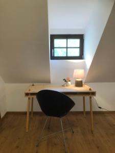 einen Schreibtisch mit einem Stuhl und einer Lampe in der Unterkunft APARTMENT ZUM ROTEN TOR in Spitz