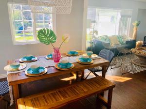 a living room with a wooden table with dishes on it at Endless summer in LA *HEATED POOL/HOT TUB/CABANA* in Los Angeles