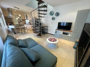 sala de estar con sofá azul y cocina en Charmante maison front de mer et centre ville en Luc-sur-Mer