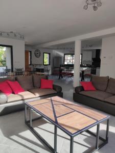 uma sala de estar com dois sofás e uma mesa de vidro em LA LOGIA Gîtes pour 20 personnes em Rilly-la-Montagne