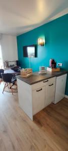 een keuken met een aanrecht met een blauwe muur bij Soleil, Vue & Confort à Tara in Port-Vendres