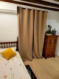 um quarto com uma cama com uma almofada e cortinas amarelas em 2 Tus vacaciones ideales en TARRAGONA em Tarragona