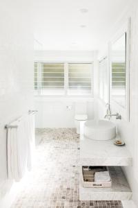 a white bathroom with a tub and a sink at The Patonga Hotel in Patonga