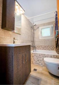 La salle de bains est pourvue d'un lavabo, d'une baignoire et de toilettes. dans l'établissement BELUGA HOUSE, à Skala Rachoniou