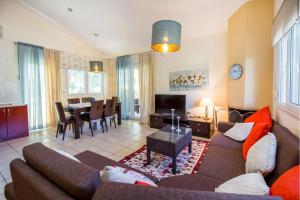 a living room with a couch and a dining room at BELUGA HOUSE in Skala Rachoniou
