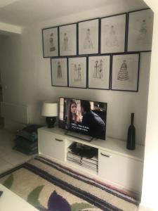 een televisie op een wit entertainmentcentrum in een woonkamer bij APARTMENT AMBLI HOUSE in Tivat