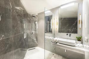 Hotel Star - Near Delhi Airport في نيودلهي: حمام مع دش زجاجي ومغسلة