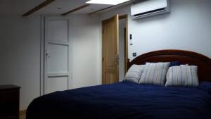 1 dormitorio con 1 cama con edredón azul en L'Eterlou Saint Blaise, bel appartement neuf mansardé, en Saint-Blaise
